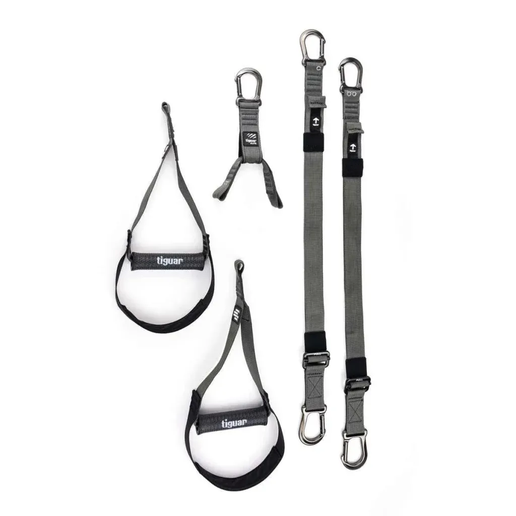 Zwei graue verstellbare Riemen mit Karabinerhaken, zwei schwarze und graue Fußfesseln und ein kurzer Verbindungsriemen, alle vor einem weißen Hintergrund. Die Gegenstände scheinen Fitness- oder Suspensionstrainingsgeräte zu sein.